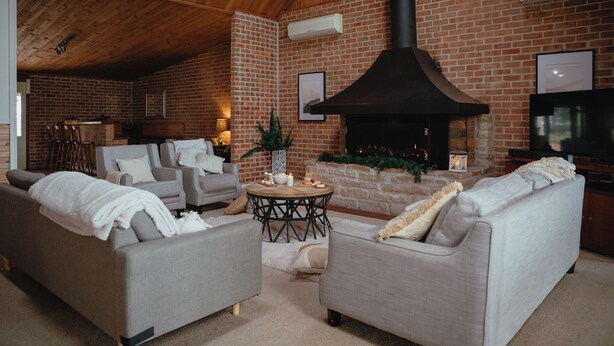 A cozy living room with a fireplace, sofas, and a TV. - Bluebush Estate (Lovedale)