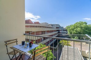 Ein Balkon mit Tisch, Stühlen und einer Wäscheleine.