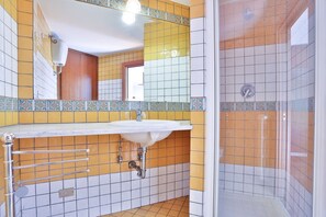 Ein Badezimmer mit Waschbecken, Spiegel und Dusche.