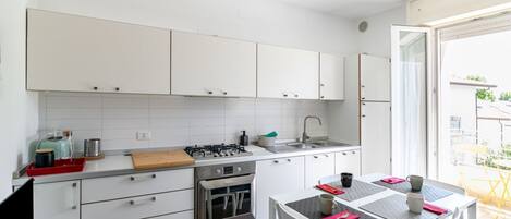 Réfrigérateur, un four, surface de cuisson, vaisselle et ustensiles