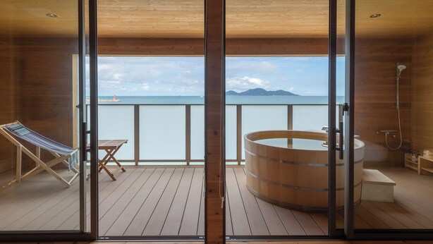A wooden deck with a wooden bathtub and a small table. - genkairyokan (Munakata)