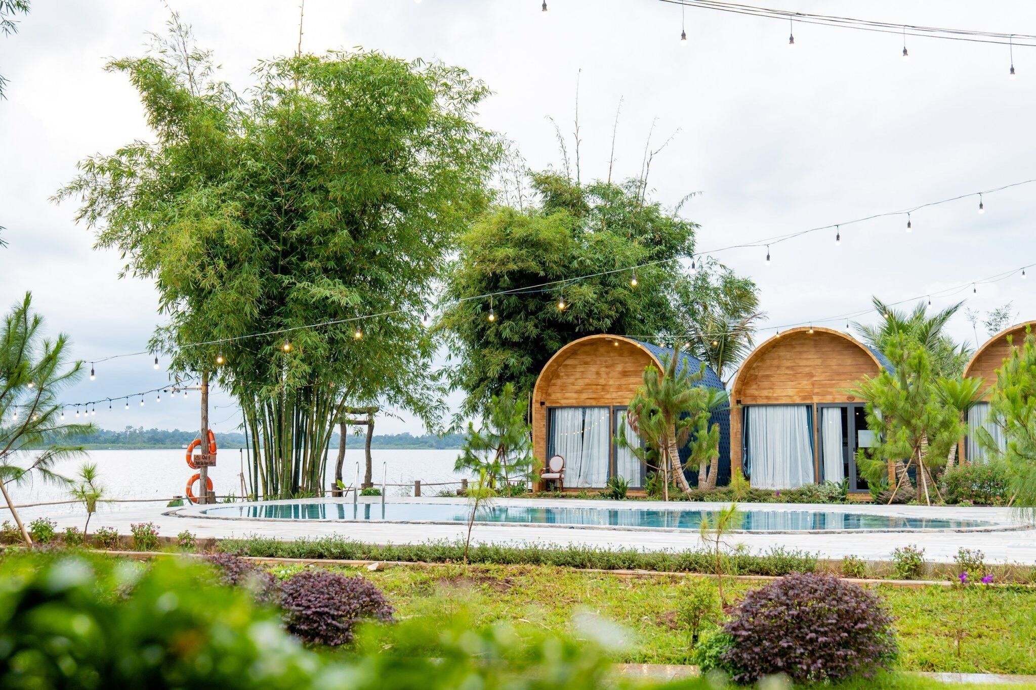 Un resort con cabine di legno, una piscina e vista sull'acqua.