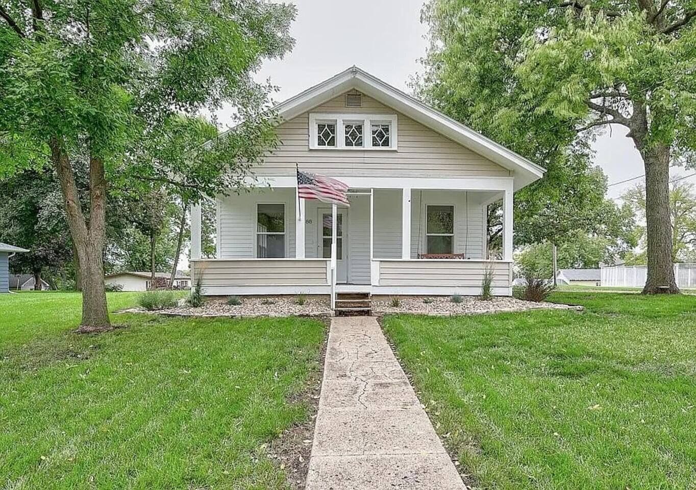 A single-story house with a front porch, a small front yard, and a pathway leading to the entrance.