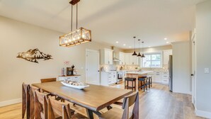 Una cocina amplia con armarios de madera, una isla central e iluminación colgante.