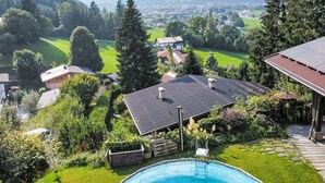 A residential area with a swimming pool, surrounded by lush greenery and houses. - zur schönen Aussicht by Interhome (Wörgl)