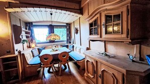 A wooden interior with a dining table, chairs, and a window with a view. - zur schönen Aussicht by Interhome (Wörgl)