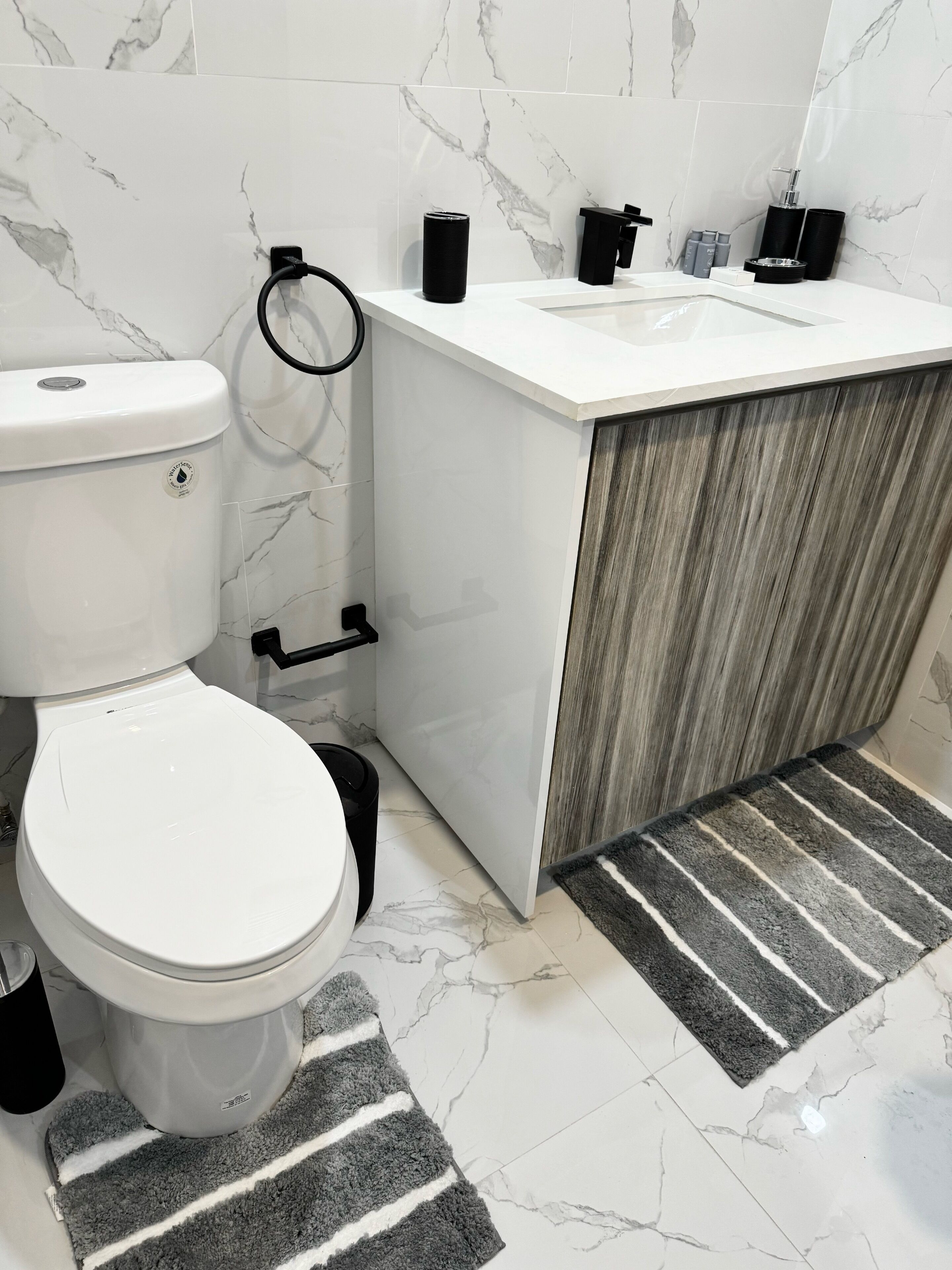 Un baño moderno con inodoro, lavamanos y tocador.