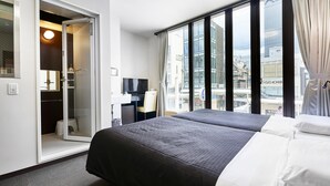 A hotel room with a bed, a desk with a chair, a mirror, and a window with curtains. - IZUTSU HOTEL KYOTO KAWARAMACHI SANJO (Kyoto)