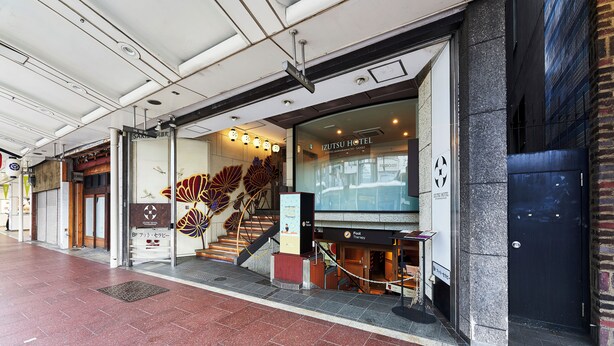 The exterior of the Izutsu Hotel with a visible entrance, a staircase leading to the entrance, and a sign indicating a foot therapy service. - IZUTSU HOTEL KYOTO KAWARAMACHI SANJO (Kyoto)