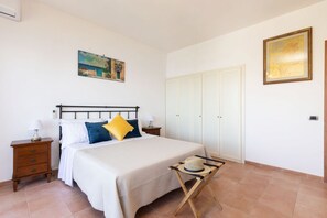 Une chambre à coucher avec un lit, des tables de chevet, une armoire et un tableau au mur.