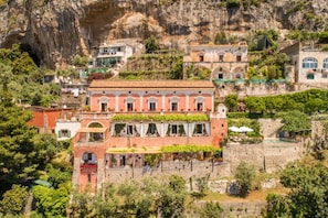 A hillside building with multiple levels, terraces, and a pool area.