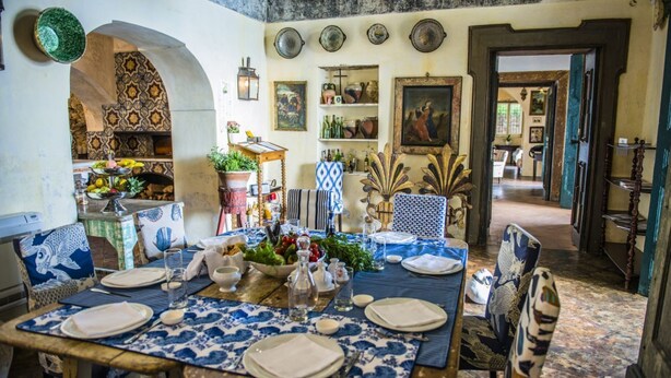 A dining area with a table set for four, surrounded by patterned walls and various decorative items. - MyExclusiveItaly - Lux Historic Villa with Pool & Amalfi Coast View (Positano)