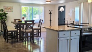 Cocina moderna con isla central, mesa de comedor de madera y sillas.