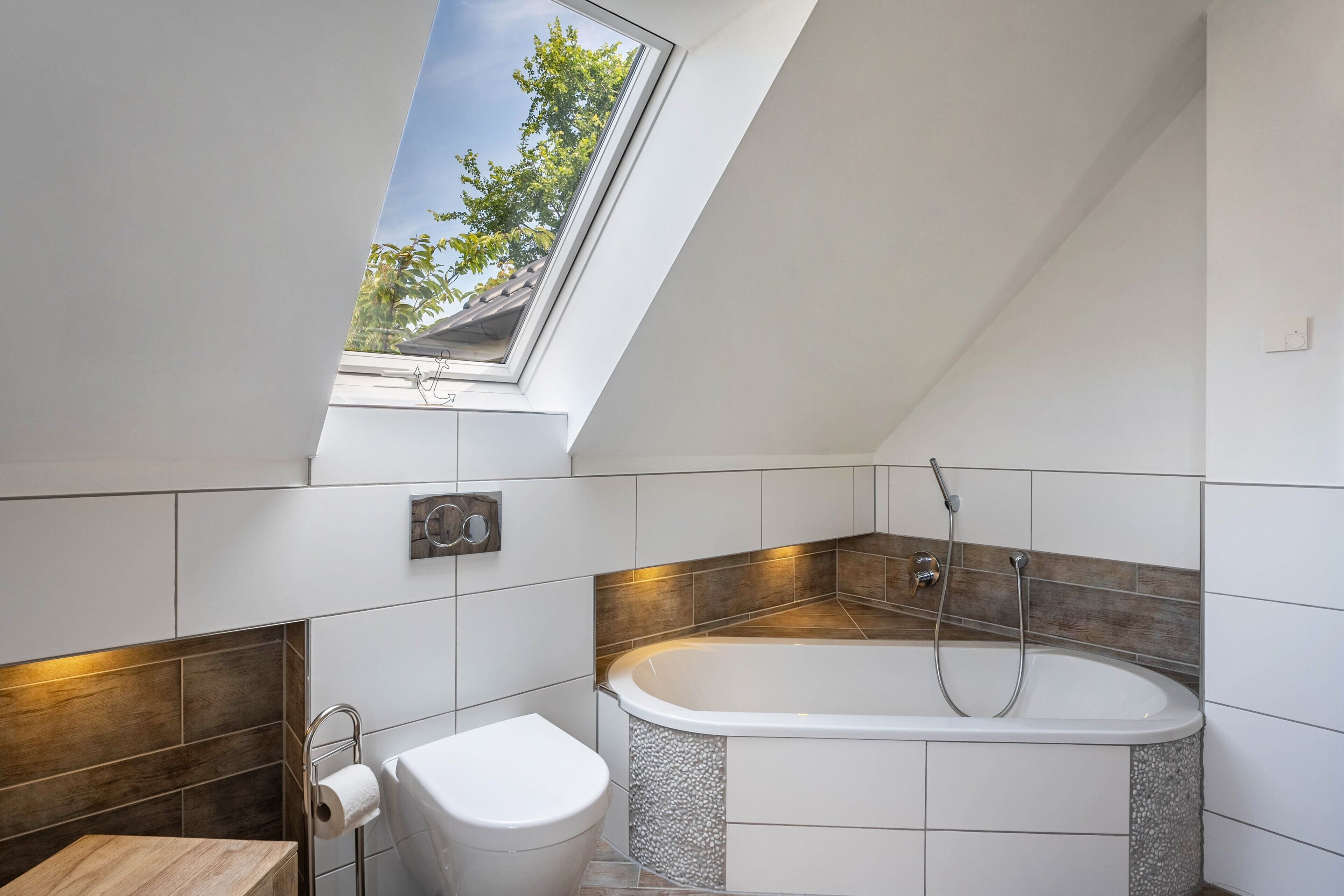 Un baño moderno con tragaluz, bañera y retrete.