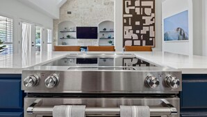 Una cocina moderna con estufa de acero inoxidable, horno integrado y una isla grande.