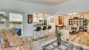 A living room with a sofa, a coffee table, and a dining area with chairs and a table. - Pet-Friendly Spring Home w/ Private Pool & Hot Tub (Spring)