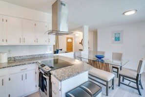 A modern kitchen with white cabinets, a granite countertop, and a built-in oven. - Covered Patio & Fire Pit: Centennial Condo! (Centennial)
