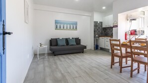 Una sala de estar moderna con un sofá gris, una mesita auxiliar y un cuadro en la pared.
