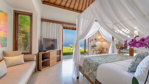 Un dormitorio con cama, televisor y vista al mar.