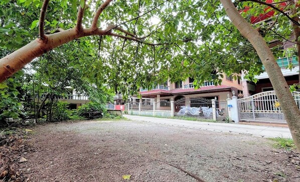 A residential area with a gated entrance, a covered porch, and a building with a red roof.