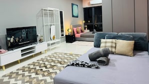 A modern living room with a flat-screen TV, a sofa, a coffee table, and a patterned rug. - CoreSoho Suite by BKAstaycation KotaWarisan Sepang KLIA Airport, Free WiFi (Sepang)