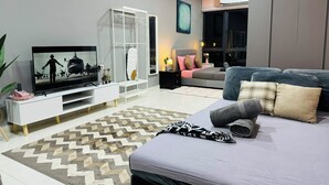 A modern living room with a flat-screen TV, a white entertainment unit, a grey sofa, and a patterned rug. - CoreSoho Suite by BKAstaycation KotaWarisan Sepang KLIA Airport, Free WiFi (Sepang)