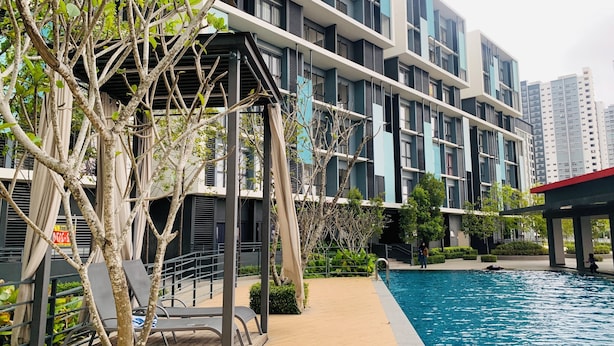 A modern building with a swimming pool, outdoor seating, and greenery. - CoreSoho Suite by BKAstaycation KotaWarisan Sepang KLIA Airport, Free WiFi (Sepang)