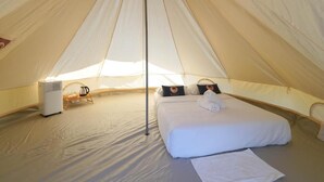 A tent with a bed, pillows, a heater, and a coffee pot. - RoomQuest Kid Tung Khao (Pak Chong)