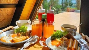 A meal setup with pasta, rice, and vegetables on a table with a view of a mountainous landscape. - RoomQuest Kid Tung Khao (Pak Chong)