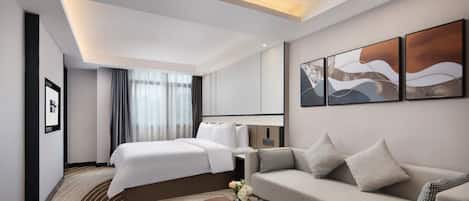 Una habitación de hotel moderna con una cama, un sofá, una mesa de centro y obras de arte en las paredes.