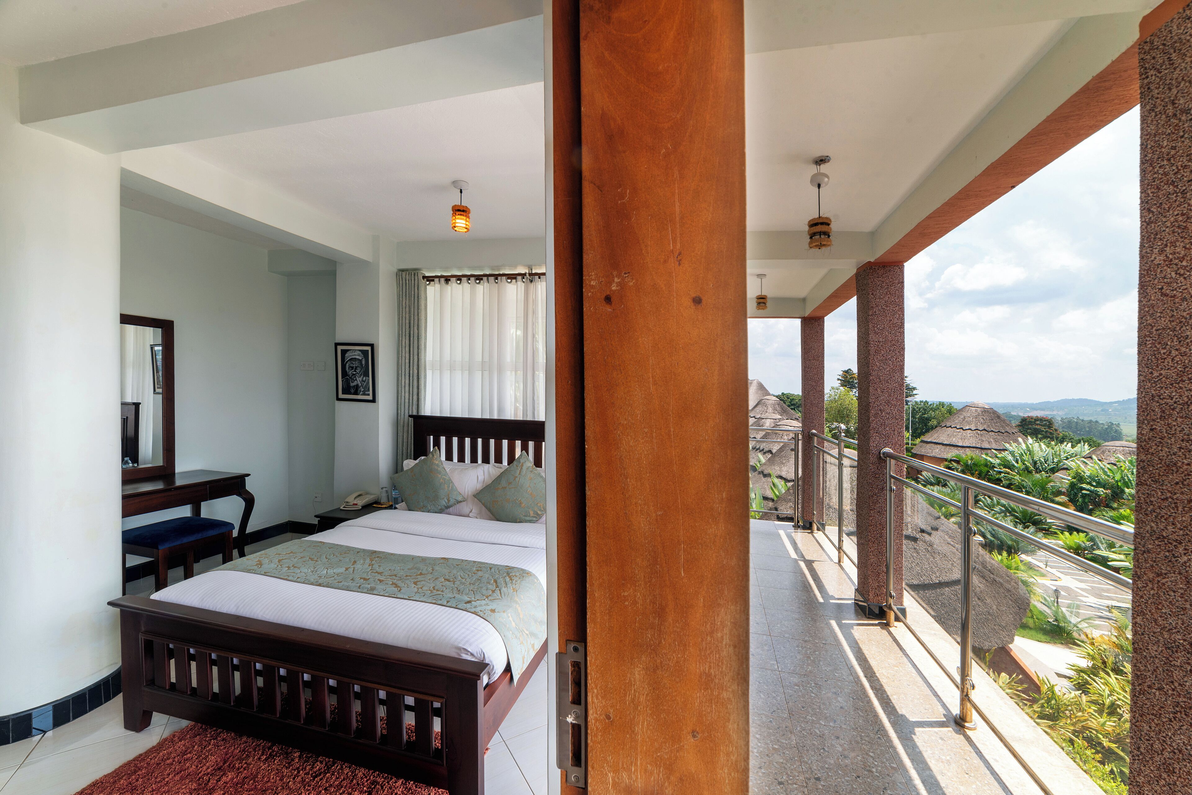 A bedroom with a bed, bedside table, and a view of the outdoors.