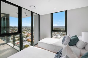 A modern bedroom with a large window, a bed, and a nightstand.