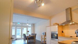Eine moderne Küche mit Essbereich, ausgestattet mit einem eingebauten Backofen, einer Mikrowelle und einem Holzschrank mit Mikrowelle darauf.