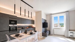 Eine moderne Küche mit eingebauten Geräten, ein Essbereich mit transparenten Stühlen und ein großes Fenster mit Blick.