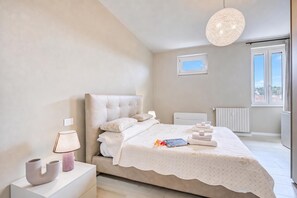 A bedroom with a bed, bedside lamp, and a view of the outside. - Viktor House Salò - 100 mt near lake (Salò)