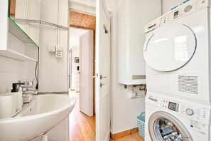 Une salle de bain moderne équipée d’un lavabo, d’un miroir et d’un lave-linge Bosch.