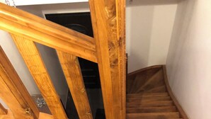 Un escalier en bois, doté d’une rampe et d’un palier.