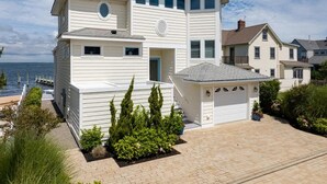 A two-story house with a garage, a dock, and a view of the water.