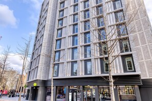 A modern building with a grid of windows, a visible entrance, and a tree in front. - Hub By Premier Inn London Marylebone (London)