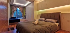 A modern bedroom with a large bed, a window with curtains, a built-in wardrobe, and a skylight.
