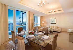 Enjoy a city view from the large window in this stylish room, featuring a dining area with a table for four and a comfortable living space.