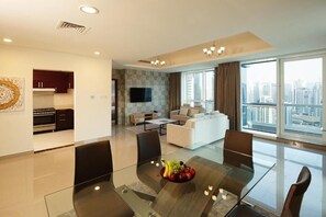 Enjoy a city view from the large window in this modern apartment, featuring a dining table, flat-screen TV, and fully equipped kitchen.