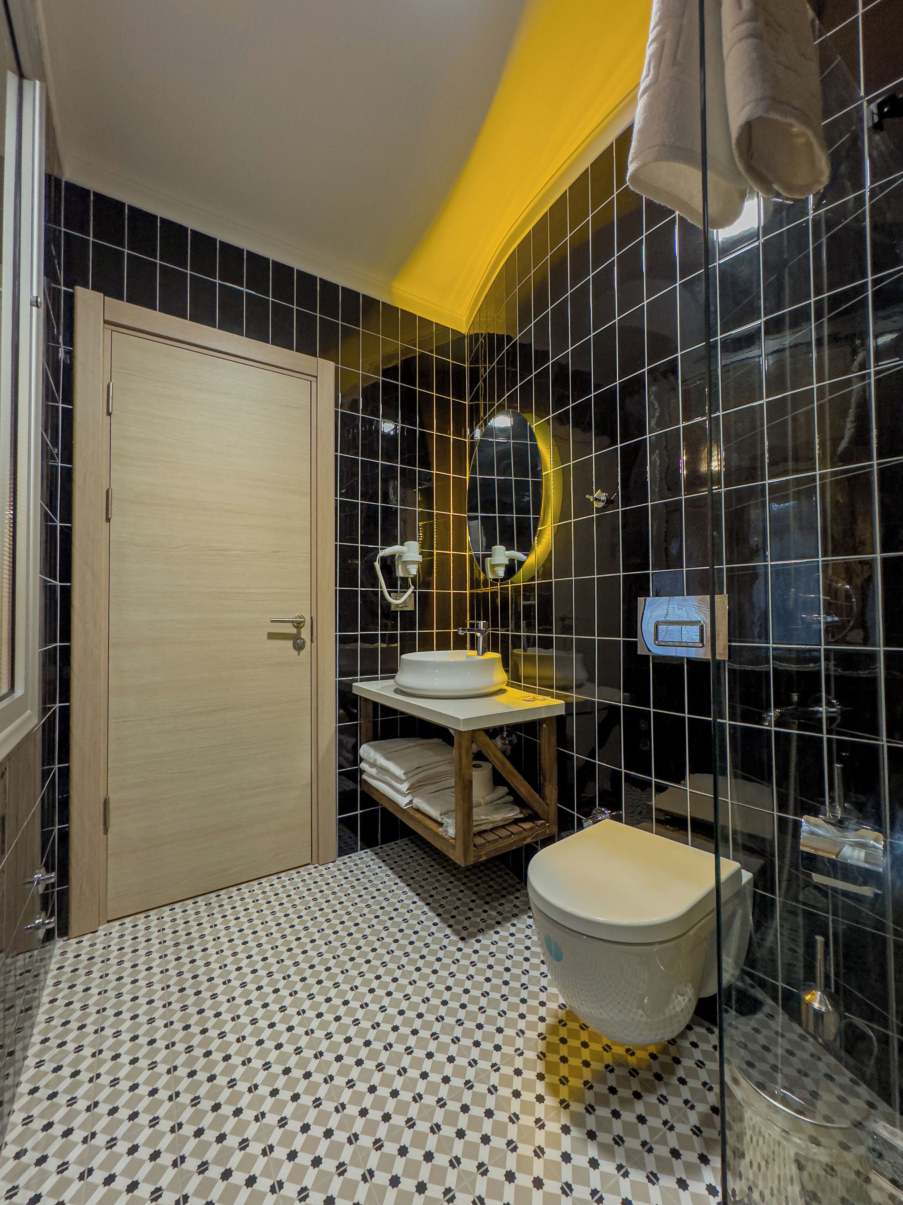 A bathroom with a toilet, sink, and mirror.