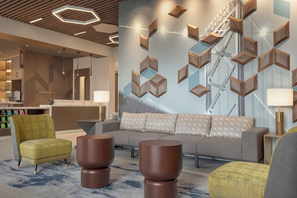 A modern lobby with a sofa, chairs, and a reception desk. - Hyatt Place Windsor (Windsor)