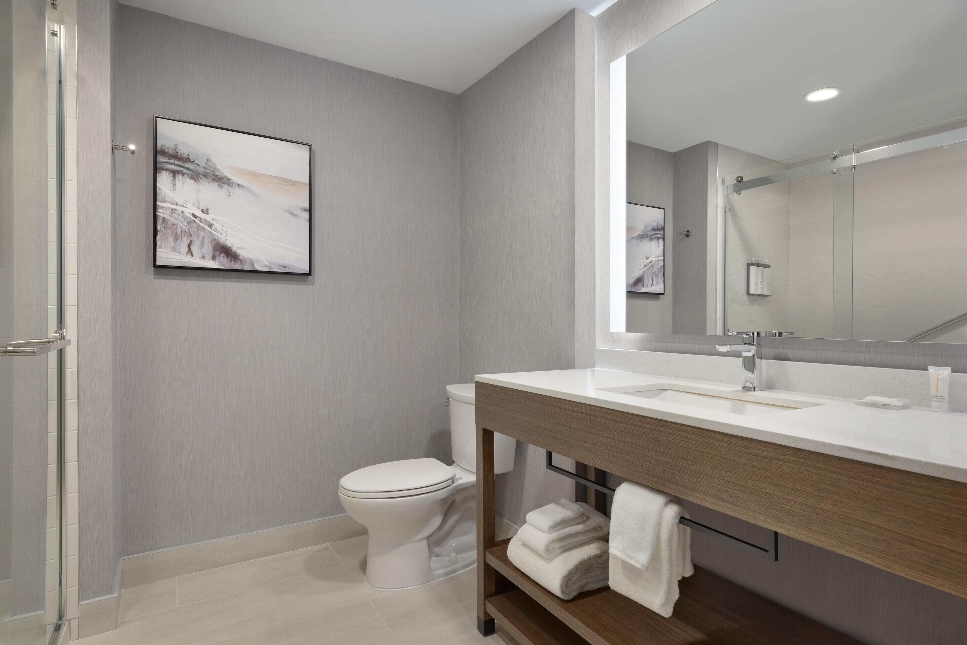 A modern bathroom with a toilet, sink, and shower area.