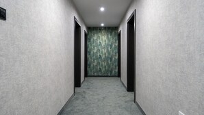 A hallway with textured walls and a carpeted floor, leading to a door with a textured wall behind it. - Apartamenty Sun & Snow Na Spokojnej (Kolobrzeg)