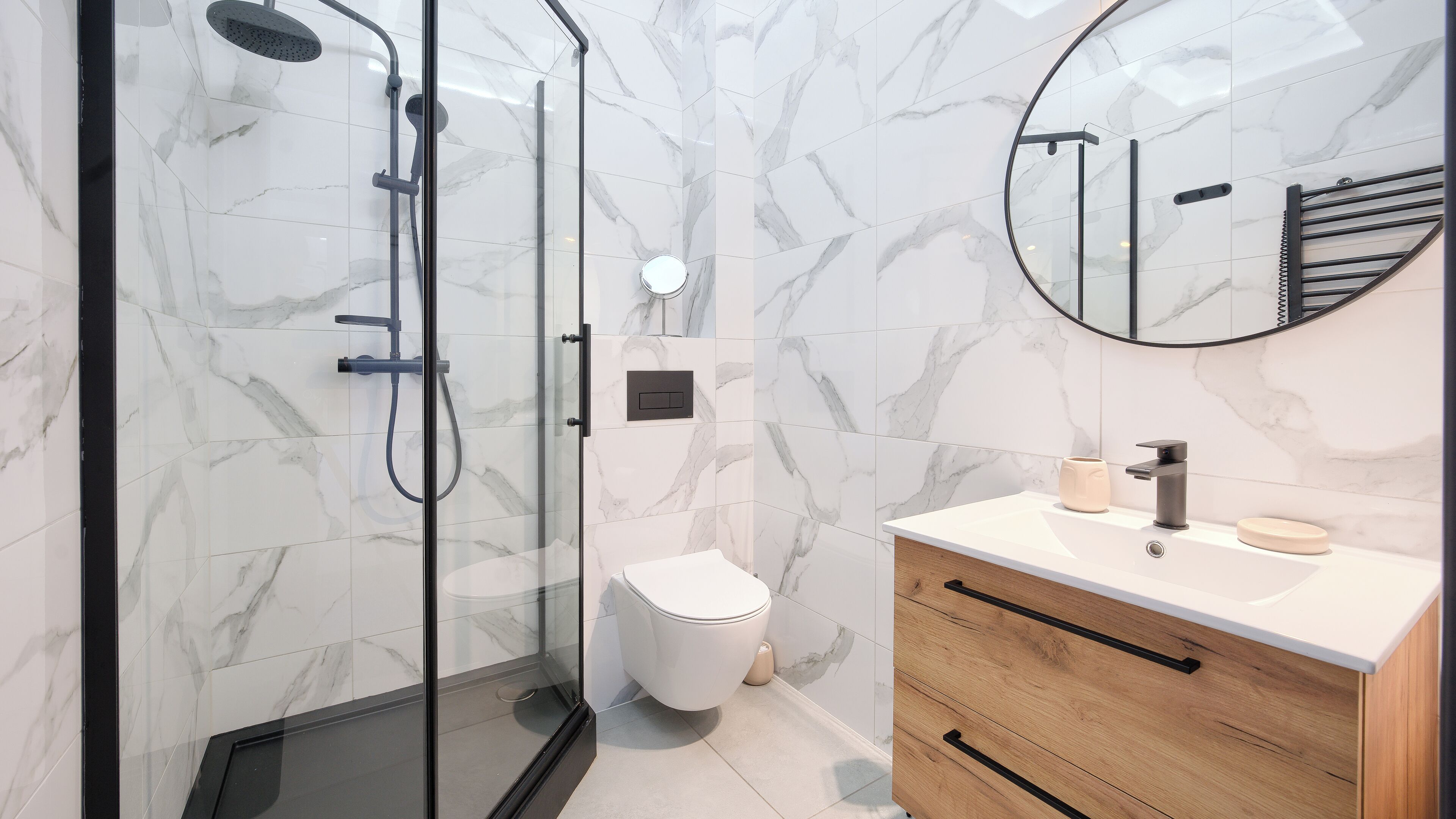 Un bagno moderno con doccia vetrata, un water e un mobile lavabo con specchio.
