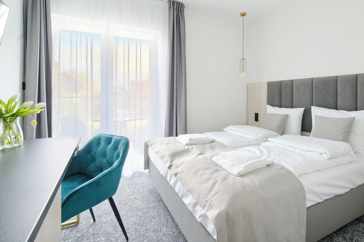 A hotel room with a bed, a desk, and a chair.