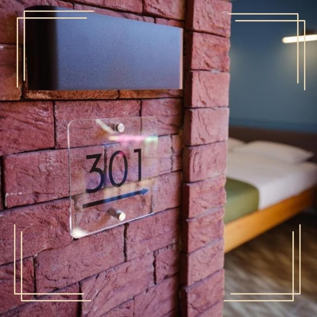 Eine Ziegelwand mit einem Schild, auf dem Zimmer 301 steht.