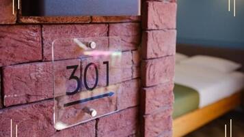 Eine Ziegelwand mit einem Schild, auf dem Zimmer 301 steht.